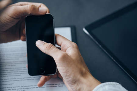 business man holding a phone, close-up.の写真素材