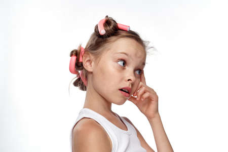 little girl with curlers on hair on white isolated background, portrait.の写真素材