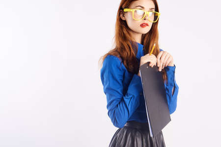 woman in yellow glasses holds a folder with documents on white isolated background.の写真素材