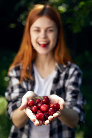 happy girl and a handful of cherries in her hand.の写真素材