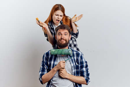 The guy and the girl misuse the roller for painting the walls.の写真素材