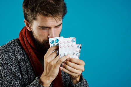 Young man choosing tablet medicineの写真素材