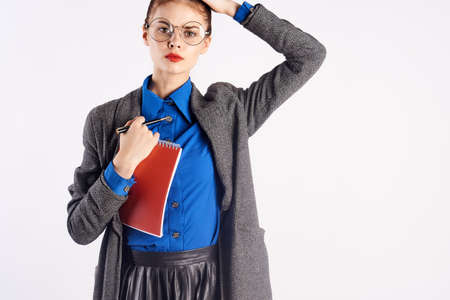 Business girl in uniform and with a notebook ready to work on a light background.