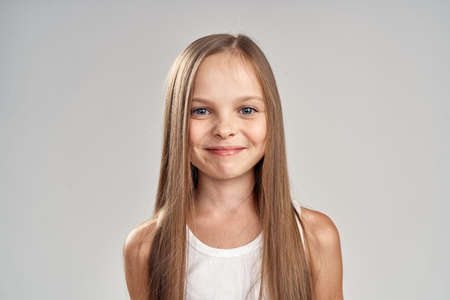 little girl with blond long hair smiling.の写真素材