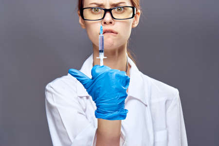 female doctor shows a syringe between the fingers.の写真素材