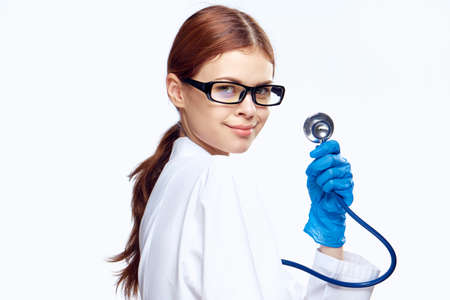 beautiful girl doctor with stethoscope looks temptingly at someone.の写真素材