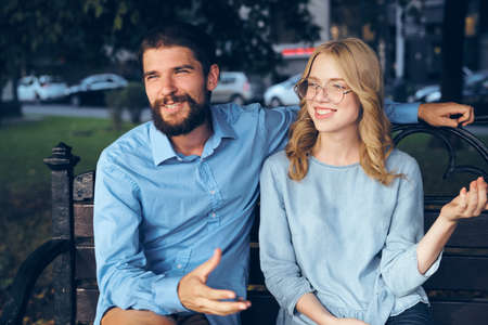 A man and a girl on a bench smile against the background of the city.の写真素材