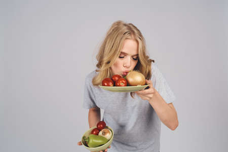 the girl is trying the vegetables on the plates.の写真素材