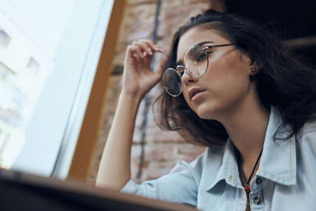 beautiful girl in round glasses from below.の写真素材