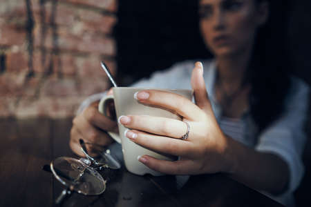 glasses, mug, hand and beautiful girl in the background.