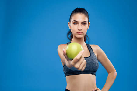 sportswoman with apple on blue background.の写真素材