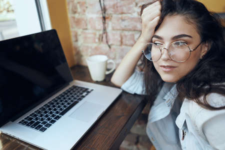 girl in glasses with laptop in cafe.の写真素材