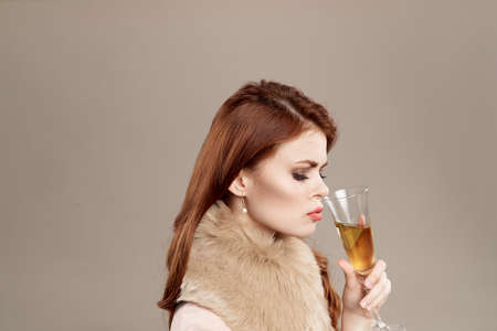 woman is sniffing a glass on a light background.の写真素材