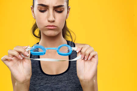 sportswoman with sunglasses for swimming on a yellow background.の写真素材