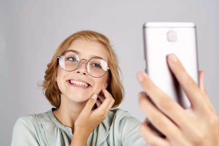 cheerful girl in big glasses does selfie.の写真素材