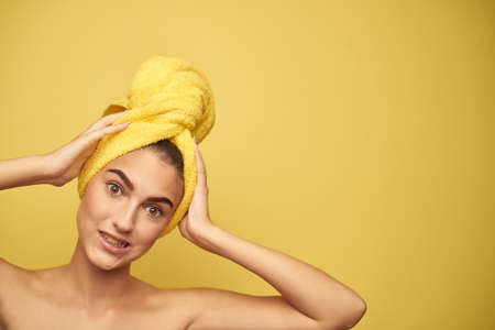 young girl with a towel on her head holding her hands behind her head.の写真素材