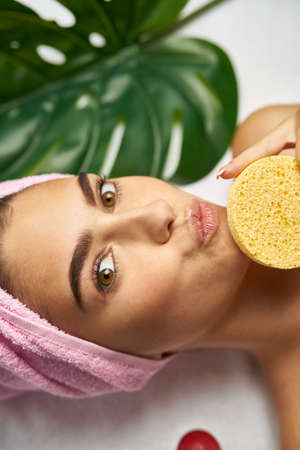 woman on spa procedure with sponge portrait.の写真素材