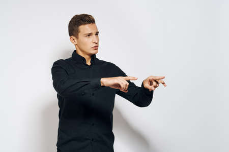 guy in black shirt shows gestures with two arms outstretched.の写真素材