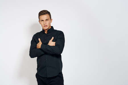 a guy in a black shirt crossed his arms against a light background.の写真素材
