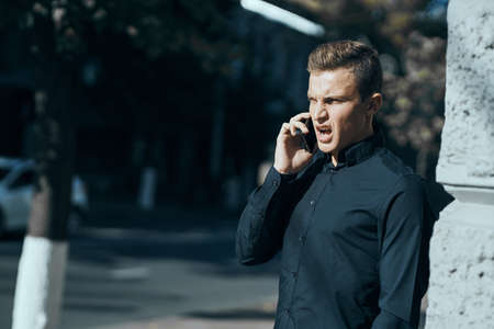 the man is talking on the phone in the street and is angry.の写真素材