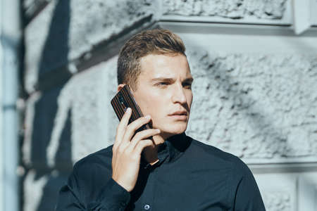 the man is talking on the phone and looking away thoughtfully.の写真素材