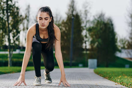 sports girl took a position for running on the street.