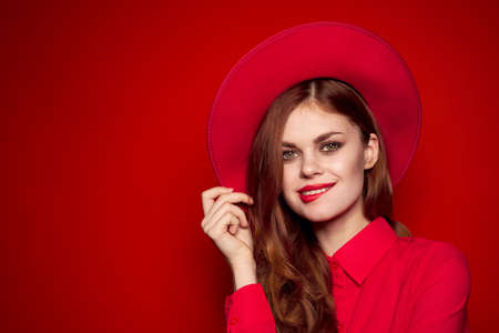 beautiful woman in a hat smiles and holds a hand by the face.の写真素材