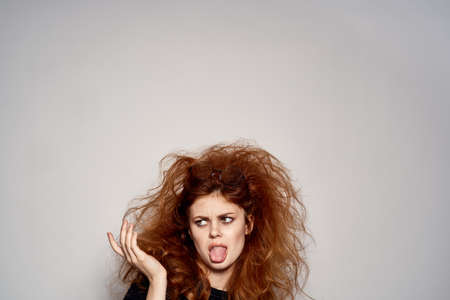 shaggy girl stuck out her tongue and points to the empty space.の写真素材