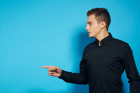 man in black shirt points finger direction.