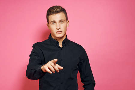 a man in a black shirt points at you.の写真素材