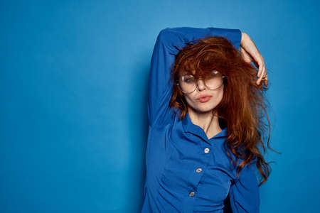 woman in glasses with brown hair with hand behind her head, a lot of free space for copying.の写真素材