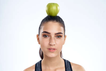 athletic girl with an apple on her head.の写真素材