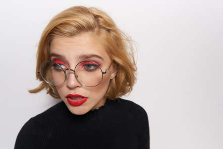 blond, glasses, bright make-up, close-up, looking away.の写真素材