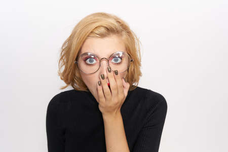 blond girl with glasses covered her face with her hand.