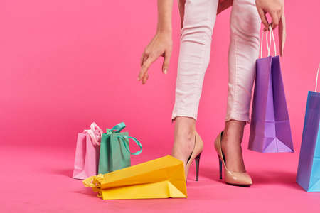 Girl's legs, hand with a package, hand reaches for the package.の写真素材