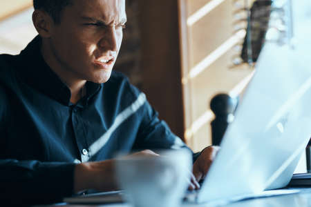 a man looks at the laptop and is angry.の写真素材