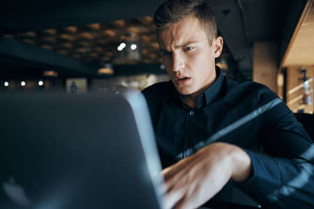 the man is displeased looking at the laptop.の写真素材