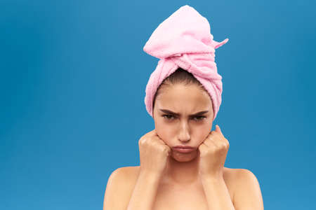 girl with a pink towel on her head gets angry.の写真素材