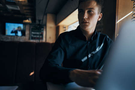 a man in a black shirt looks away.の写真素材