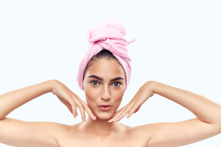 girl with a towel on her head with her hands near her face.の写真素材