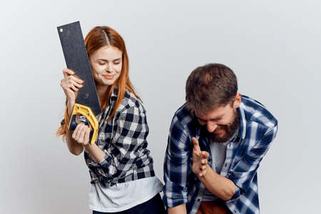 Man and woman can not understand how to use a working tool and have fun.の写真素材