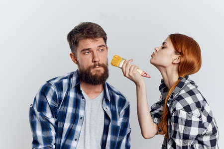woman trying to paint a man with yellow paint.
