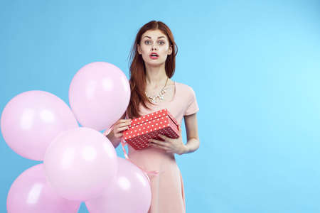 woman surprised, box, balloons, blue background.の写真素材