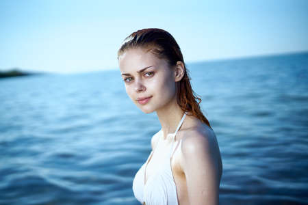 a girl emerging from the water on the background of the sea.の写真素材