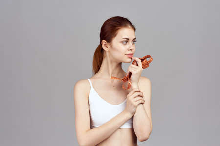 slender girl holding a tape for measuring the waist.の写真素材