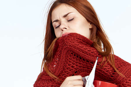 sick woman covered her face with a red scarf, close-up.の写真素材