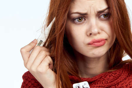 a sick woman, a thermometer, a red scarf, a portrait.の写真素材
