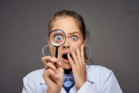 the doctor is looking at the magnifying device and is very much surprised.の写真素材