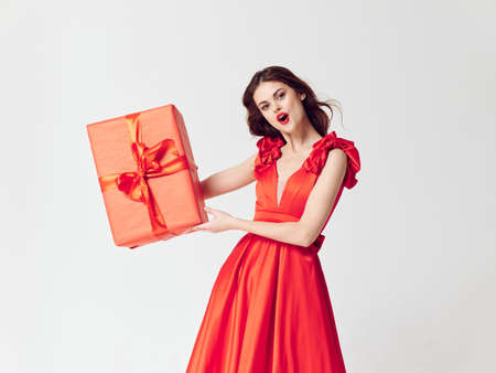 Woman in a beautiful dress with gift holiday boxes in the studioの写真素材