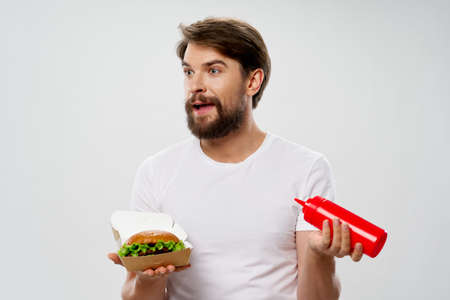 Young man with a juicy hamburger a man eating a burgerの写真素材